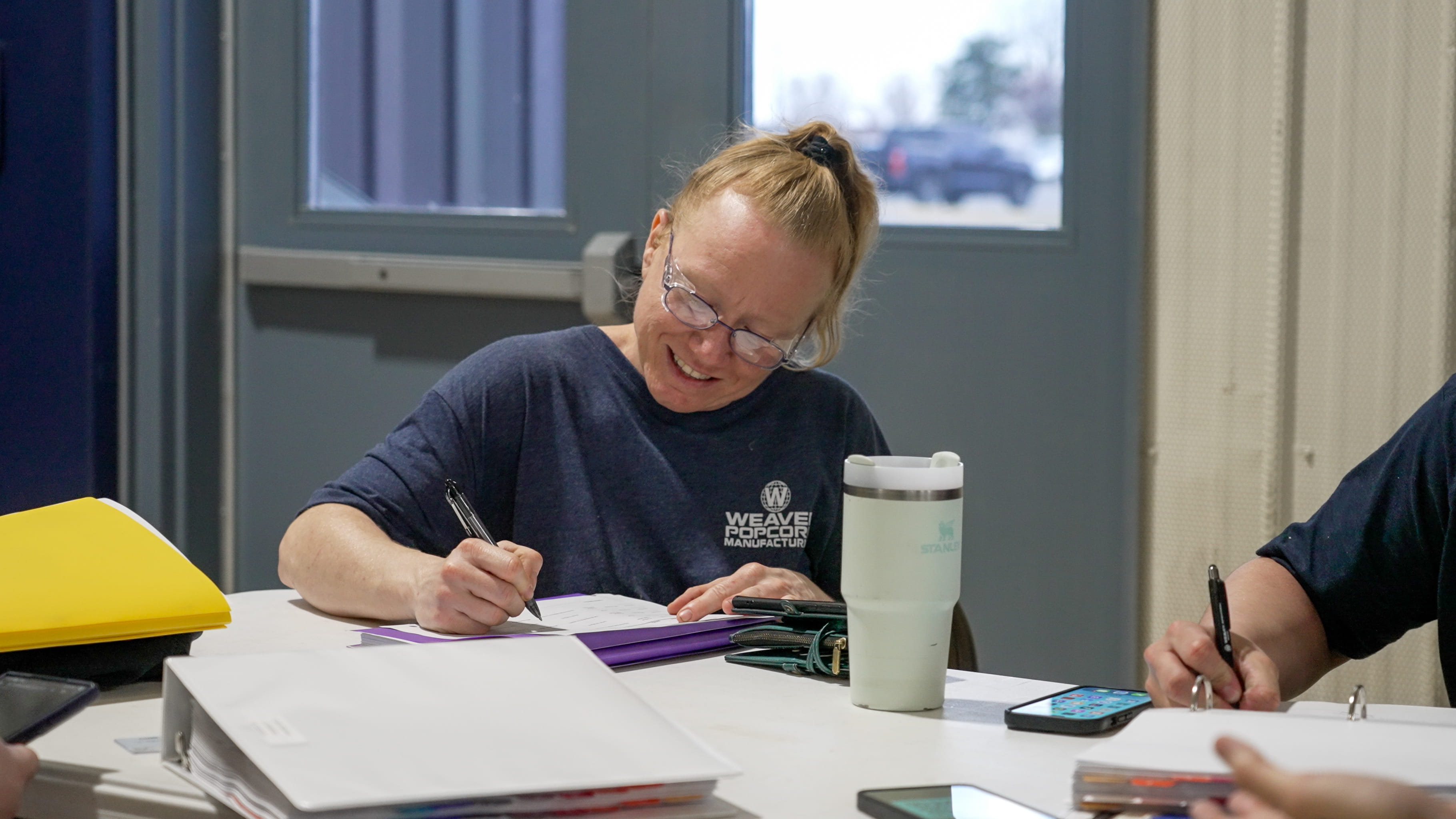 Employee Smiling As She Works on Documents