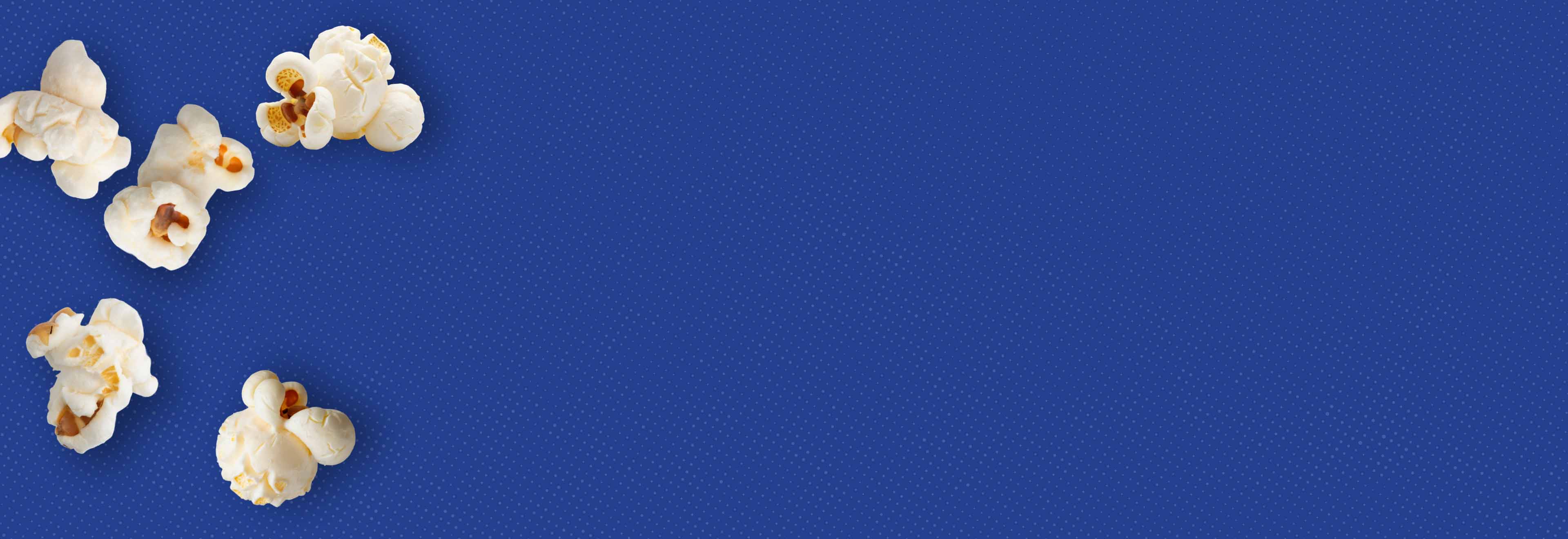 Blue background with half-tone effect and popped popcorn kernels.