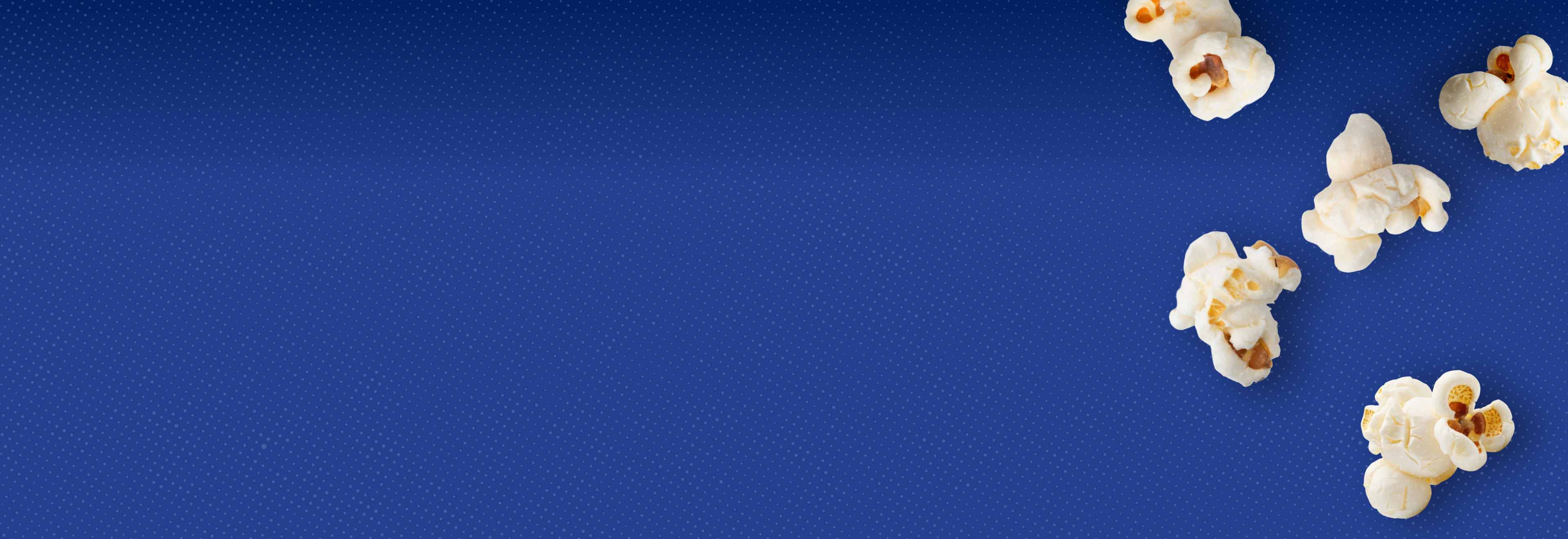 Blue background with half-tone effect and popped popcorn kernels.
