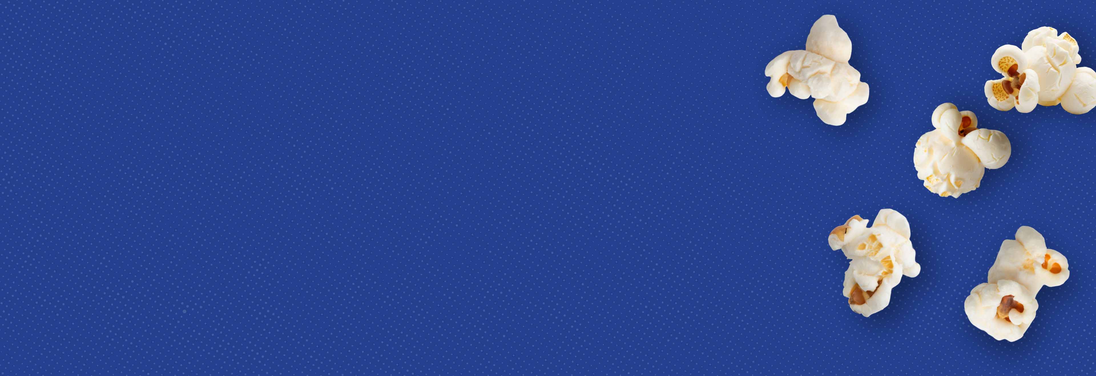 Blue background with half-tone effect and popped popcorn kernels.